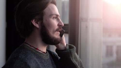 Man Chatting on Cell Phone by Sunny Window