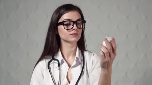 Doctor Shows Bottle with Drugs