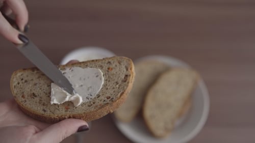 Spreading Cream Cheese on Multigrain Bread Slice
