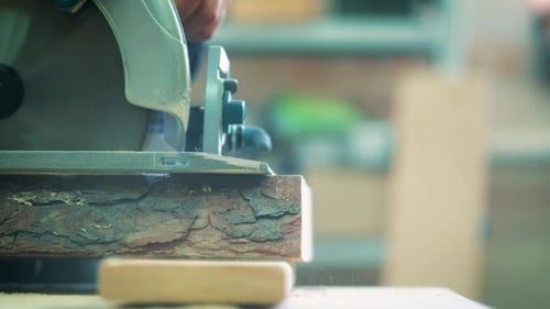Man Cutting Wood with an Electric Circular Saw