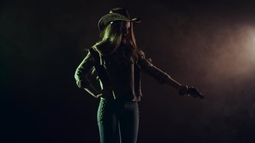 Cowboy Girl Takes Out a Revolver and Makes a Shot. Black Smoke Background. . Side View