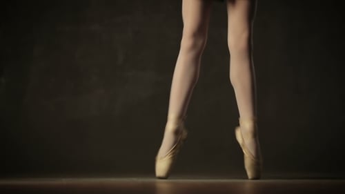 Graceful Ballerina Practicing Ballet Footwork on Stage