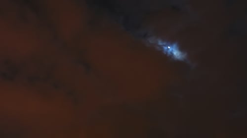 Bewölkter Himmel bei Nacht mit Mond über der Stadt