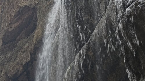 Eisiger Wasserfall auf einem schwarzen Felsen