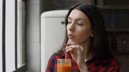 Woman Drinks Beverage by Window