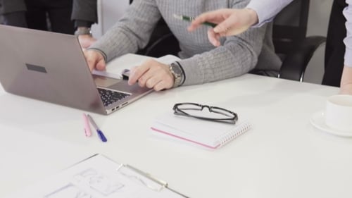 Team Collaborating Around Laptop in Modern Office