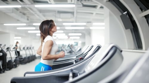 Woman Running on Sole Treadmill in the Gym