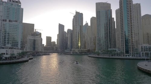 Ship Floating on Dubai Marina Between Glass Skyscrapers in United Arab Emirates