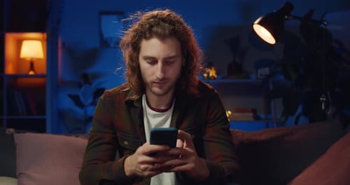 Front View of Concentrated Young Man Typing Message While Chatting in Social Networks at Home