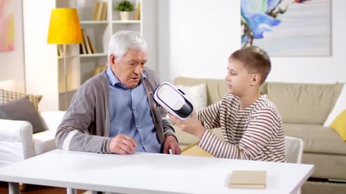 Boy Helps Senior Man with VR Headset