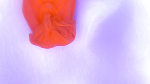 Orange Paint Spreading in Lavender Liquid Background