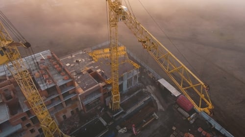 Construction Site in the Fog with a Bird's Eye with Tower Cranes on the Sunset.
