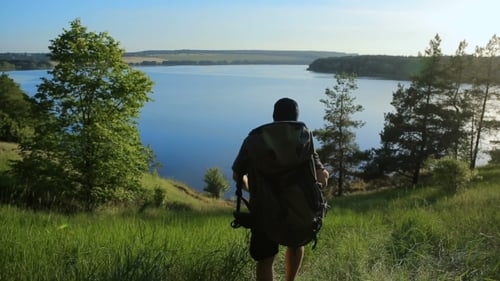 Man With Backpack Walks Toward Lake