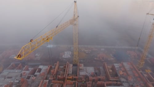 Construction Site in the Fog with a Bird's Eye with Tower Cranes on the Sunset
