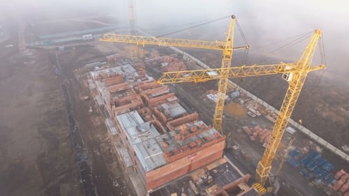 Construction Site in the Fog with a Bird's Eye with Tower Cranes on the Sunset