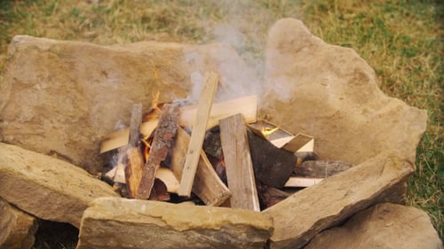 Kindling Campfire Surrounded By Stones Burns in Daylight