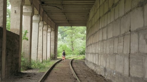 Junges Mädchen geht auf der Eisenbahn im Tunnel
