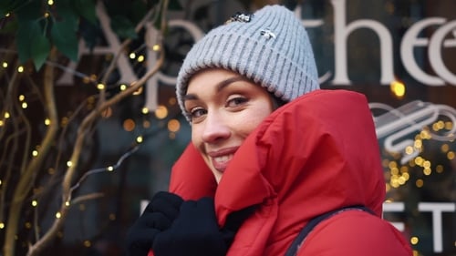 Beautiful Woman in Red Winter Jacket Walks Along the Street Covered with Snow in a Beautiful Old