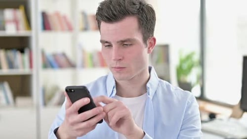 Young Adult Using Mobile Phone Indoors