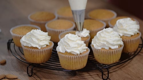 Frosting Cupcakes with Cream in a Bright Kitchen