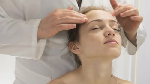 Woman Receives a Relaxing Face Massage in Clinic