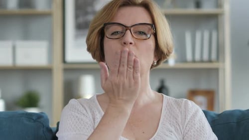 Woman Sitting on Couch Blowing Kisses