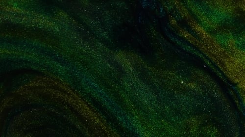 Green Emerald Ink Reacting in Red Water Creating Abstract Background.