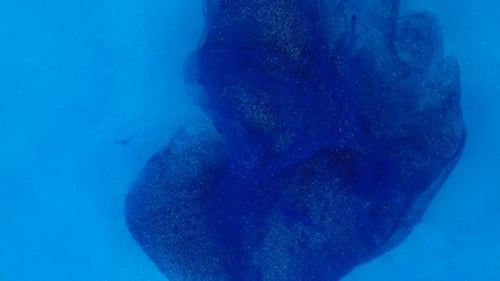 Blue Ink Swirling in Clear Liquid Abstract