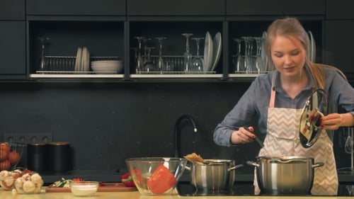 Blonde Woman Cooking Spaghetti Sauce in Kitchen