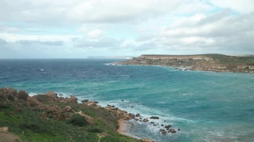 AERIAL: Beautiful Turquoise Colour Sea Water Rolls Waves to Ghajn Tuffieha Bay