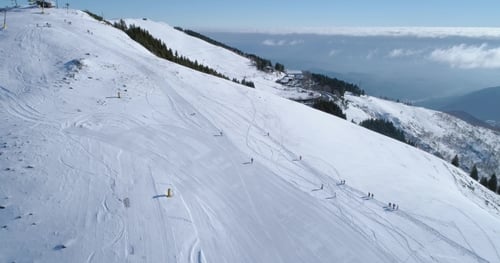 Winter Snowy Mountain Ski Track Field with People in Sunny Day