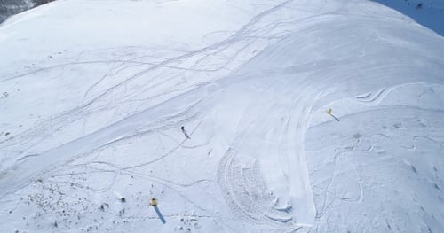 Aerial Follow Over Skier Alpine Skiing in Winter Snowy Mountain Ski Track Field in Sunny day.Above