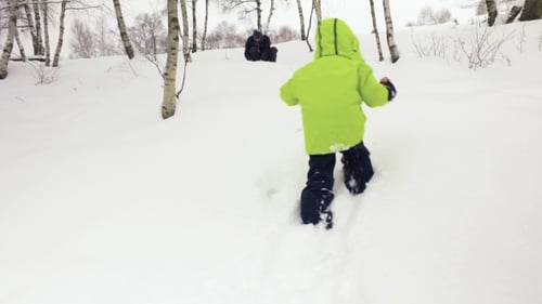 Winter Follow Little Child Walking To Father Playing with Snow in Snowy Field. Family People Have