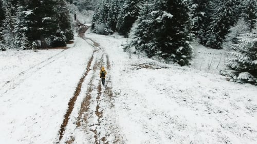 Man with a Backpack Is Going Up the Mountain in Winter. Watching From the Above