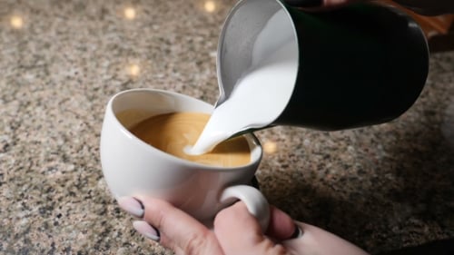 Pouring Milk into Cup of Coffee