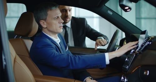 Man in Car Demonstrating Dashboard Touchscreen