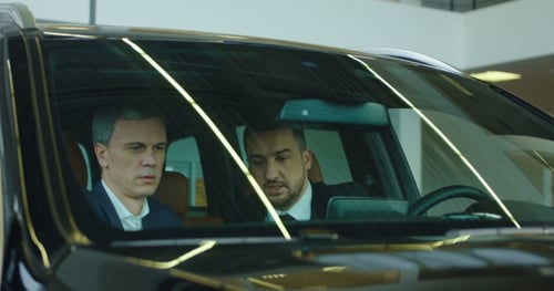 Two Men Discussing a Car Inside a Showroom