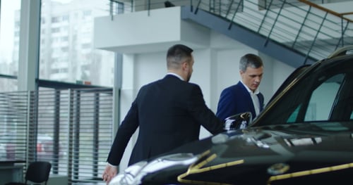 Men Looking at Luxury Car at Dealership