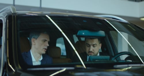 Men in Suits Discussing Business in Car
