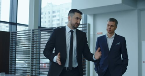 Businessmen Discuss Deal in Modern Car Dealership