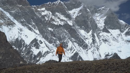 Man with Backpack Climb the Mountain Slope in the Himalayas
