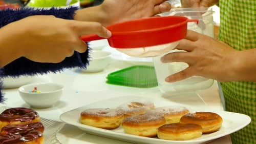 Die Donuts mit Puderzucker bestreuen