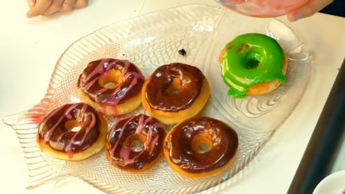 Decorating Delicious Colorful Donuts with Glaze