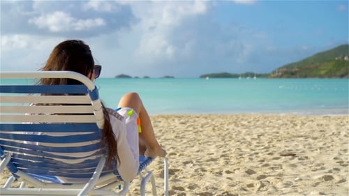 Woman Sunbathing on a Lounger at Tropical White Beach