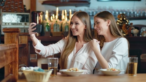 Two Beautiful Women Taking Selfie in Cafe
