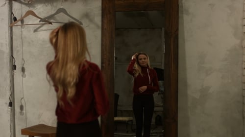 Woman Adjusting Hair and Posing in Front of Mirror