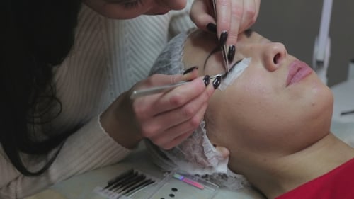 Procedimento de extensão de cílios. Olho de mulher com cílios longos.