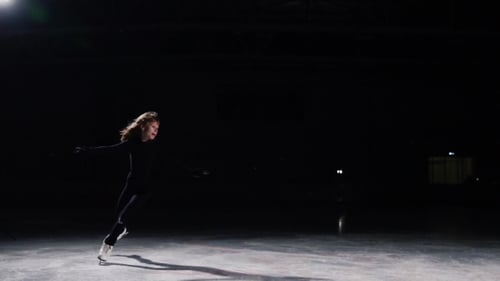 Girl Spins Gracefully Ice Skating on Rink