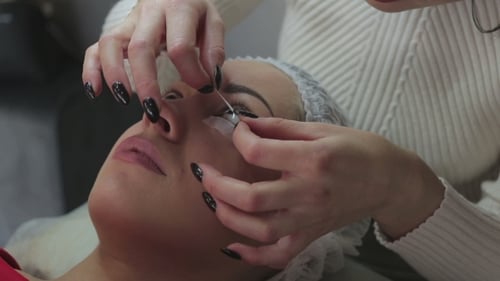 Eyelash Extension Procedure. Woman Eye with Long Eyelashes