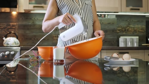 Mixing Dough in Bowl with Motor Mixer. Woman Preparing a Dough. Cooking Cake.